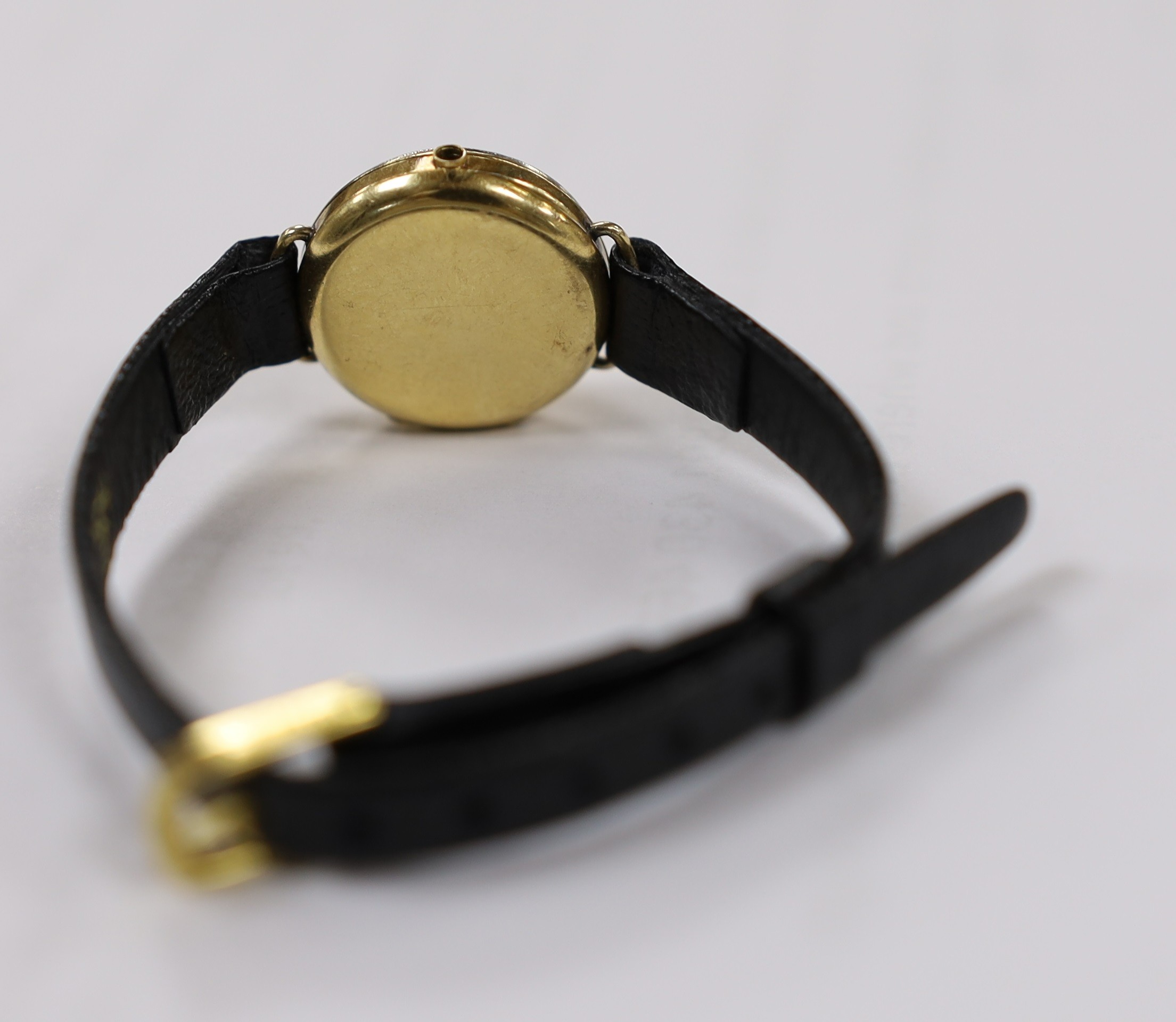 A lady's 18k manual wind wrist watch, with diamond set bezel and dial with baton numerals (a.f.), on a leather strap, lacks winding crown.